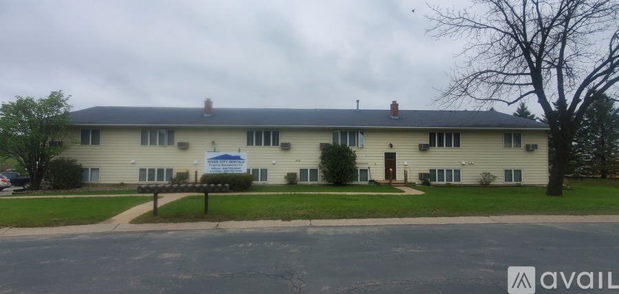 A two-story building with a sign in front that says "available".