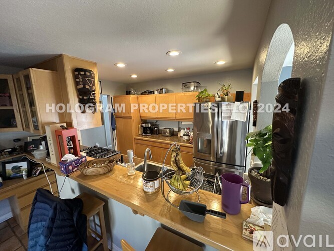 A kitchen with a wooden counter and a bowl of bananas on it.