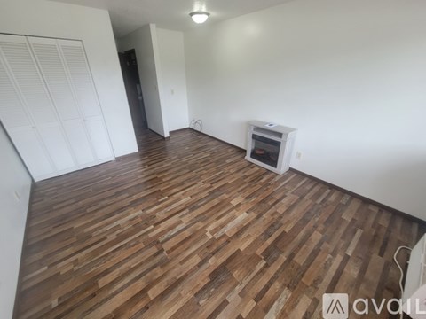 A room with wooden flooring and a window.