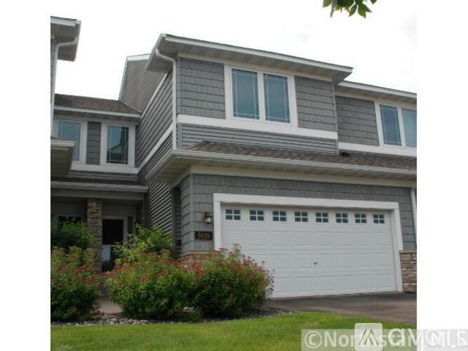 A two-story house with a garage and a white door.
