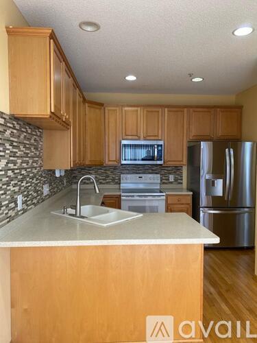 A kitchen with wooden cabinets and a stone backsplash.