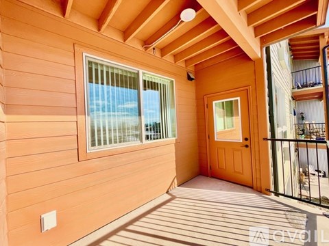 A wooden deck with a door leading to a balcony.