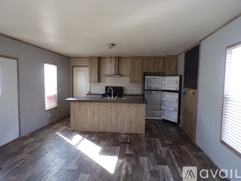 A kitchen with wooden cabinets and a refrigerator.