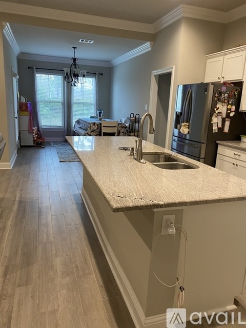 A kitchen with a granite countertop and a refrigerator with magnets.