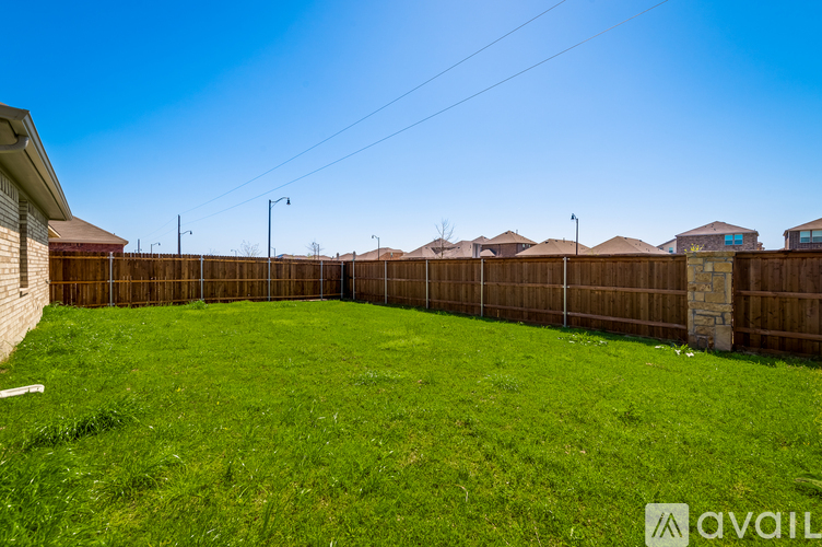 A backyard with a wooden fence and a grassy area.