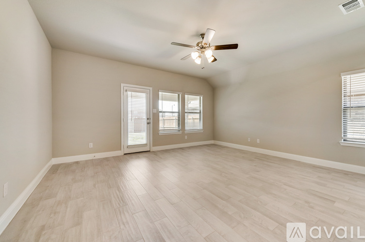 A spacious room with a ceiling fan and sliding glass doors.