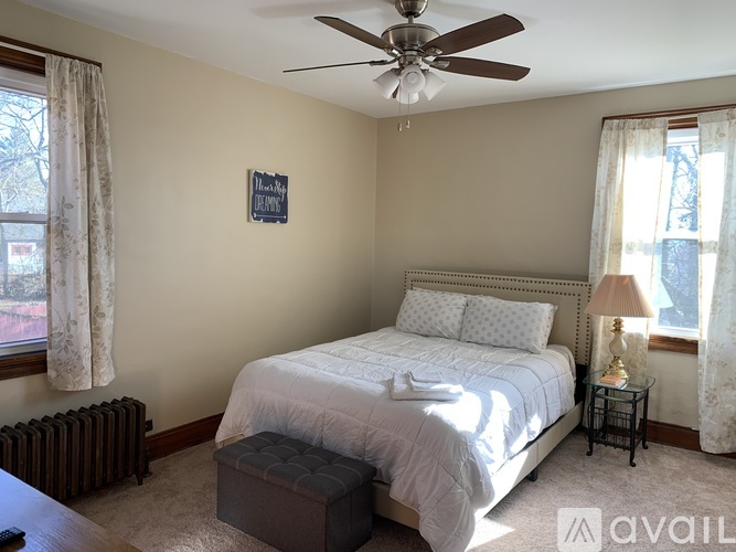 A bedroom with a bed, nightstand, and window.