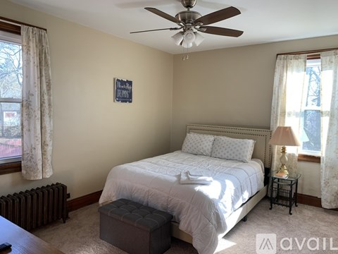 A bedroom with a bed, nightstand, and window.