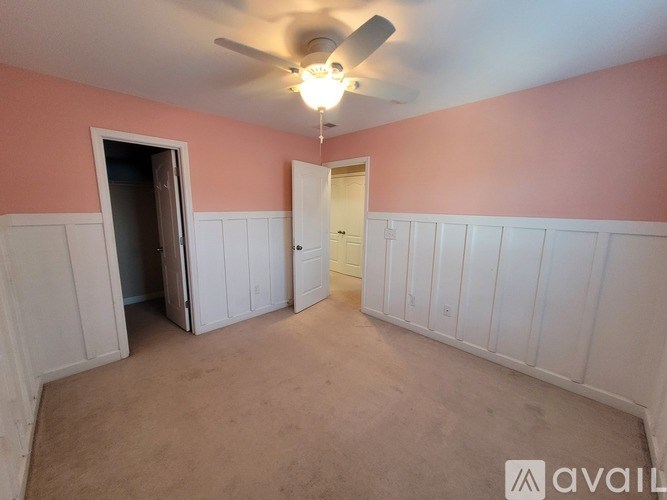 A room with a ceiling fan and two doors, one of which is open.