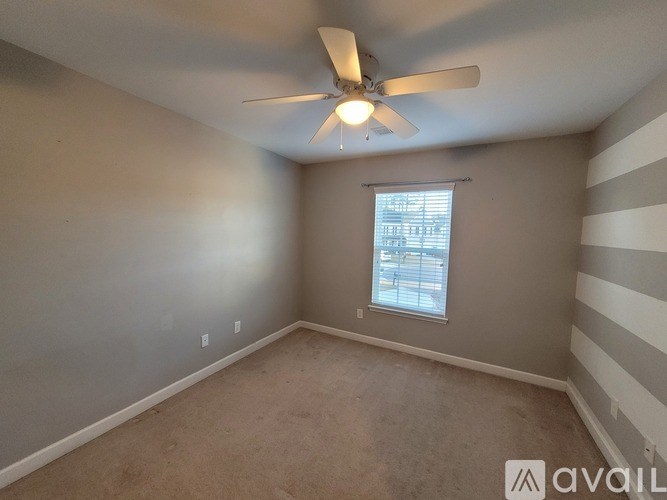 A room with a ceiling fan and a window.