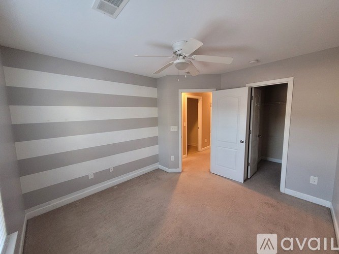A room with striped walls and a ceiling fan.