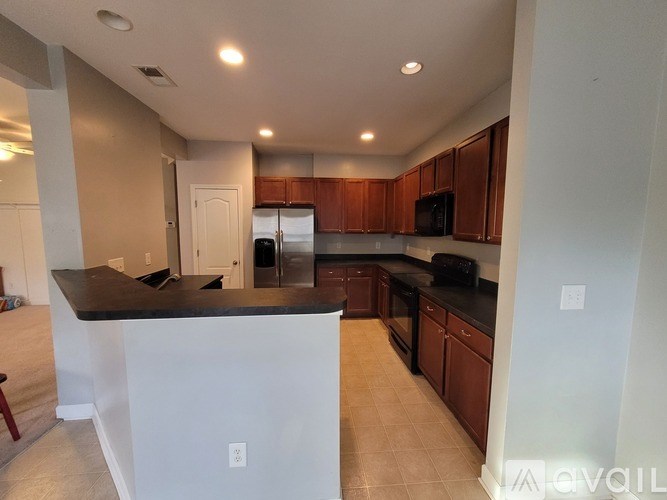 A kitchen with brown cabinets and black countertops.