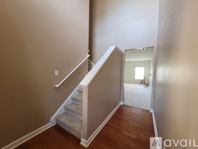 A hallway with a staircase leading to a bedroom.