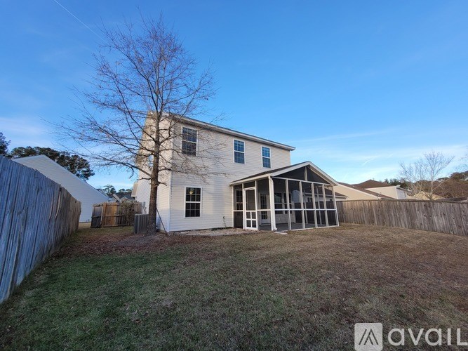 A house with a white exterior and a large backyard.