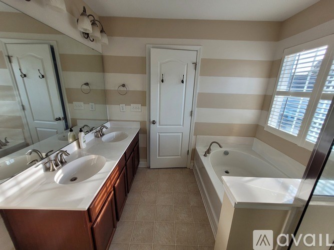 A bathroom with striped walls and a bathtub.