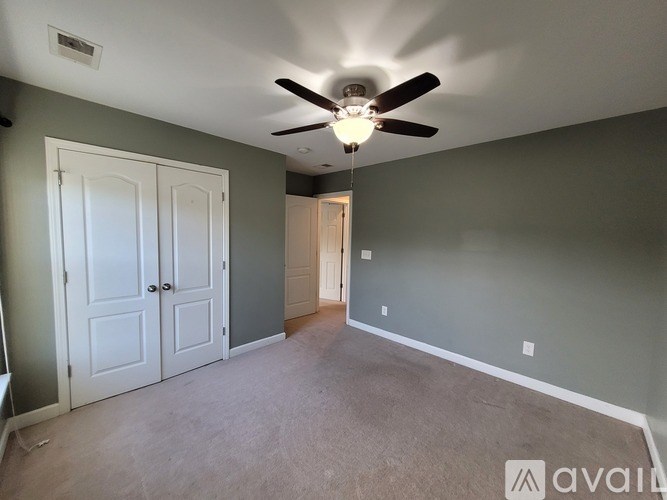 A room with a ceiling fan and two doors.