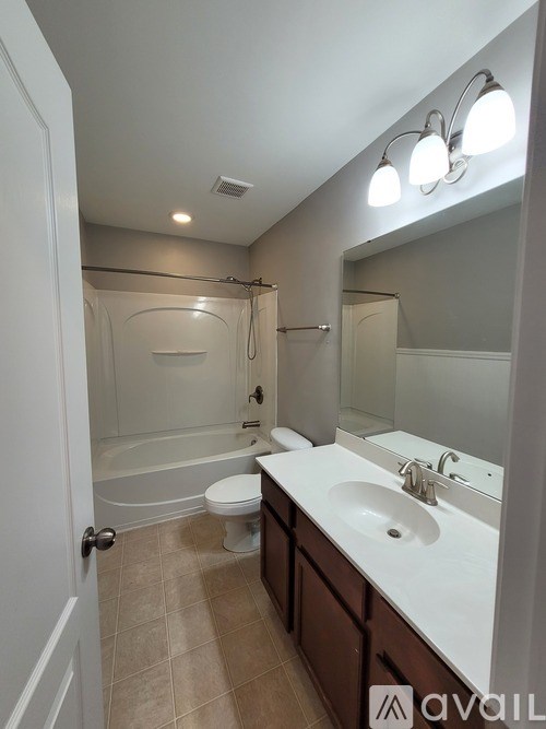 A bathroom with a toilet, sink, and bathtub.