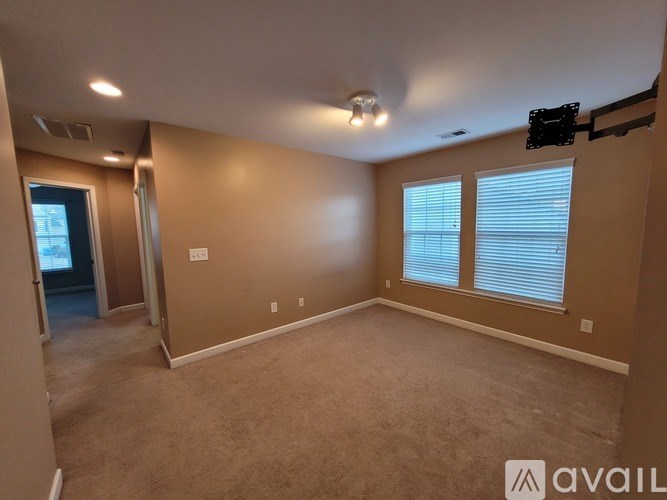 A room with beige walls and carpeted floor.