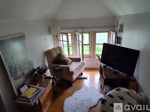 A living room with a television, a chair, and a painting on the wall.