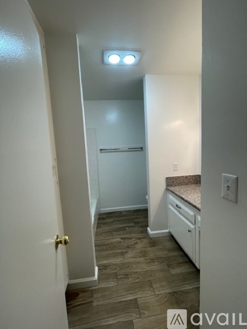 A small white room with a bed and a refrigerator.