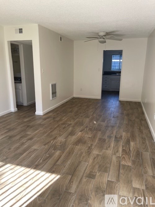 A room with wooden flooring and a ceiling fan.