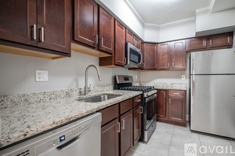 A kitchen with brown cabinets and a granite countertop.