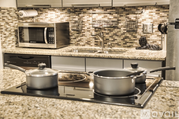 A kitchen with a stove top and two pots on it.