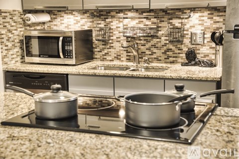 A kitchen with a stove top and two pots on it.