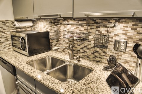 A modern kitchen with a granite countertop and stainless steel appliances.
