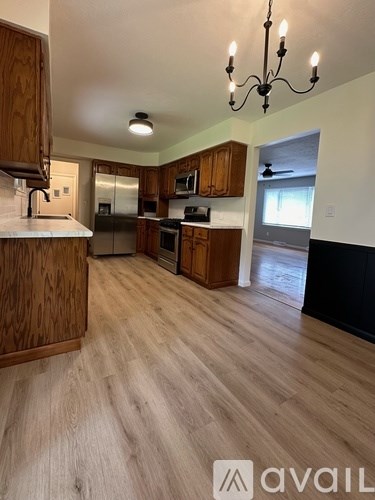 A kitchen with wooden cabinets and a chandelier.