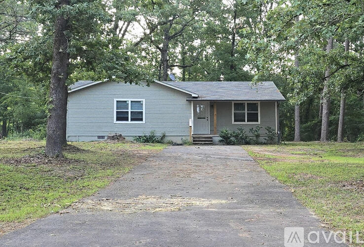 A house with a grey roof and a grey front porch with a white door and two windows.