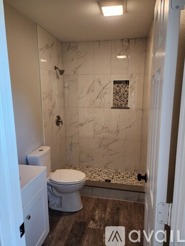 A white toilet sits in a marble bathroom.