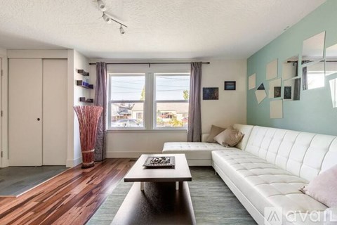 A living room with a white couch and a wooden coffee table.