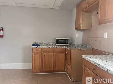A kitchen with wooden cabinets and a granite countertop.