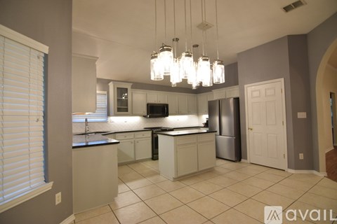 A kitchen with a refrigerator, sink, and cabinets.
