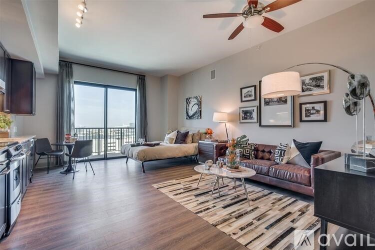 A living room with a brown couch, a white coffee table, and a ceiling fan.