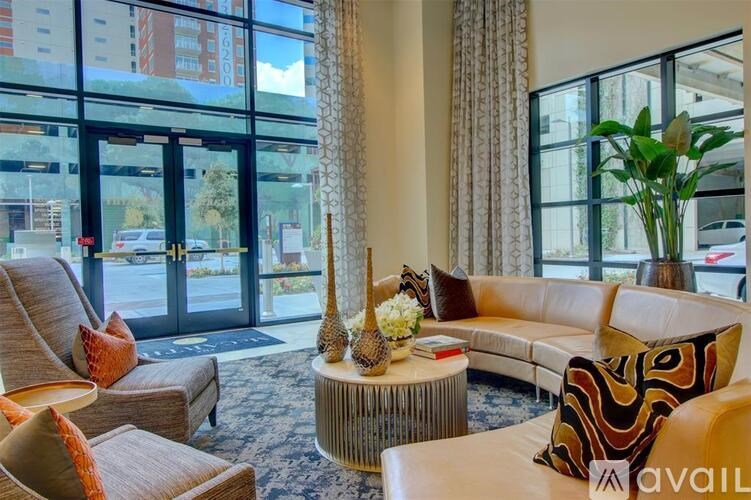 A living room with a large window and a view of a parking lot.