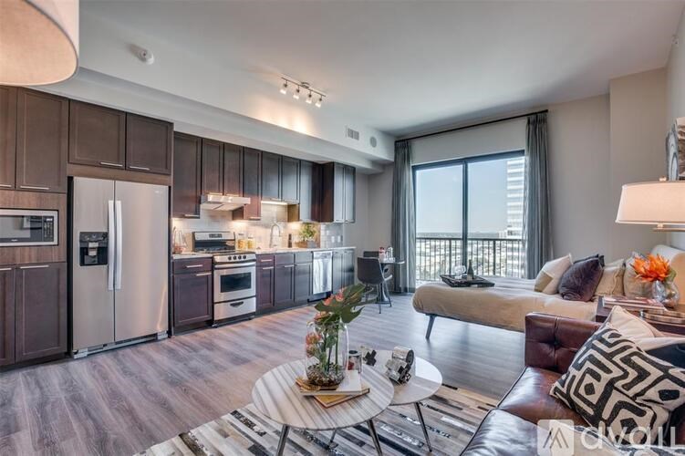 A modern kitchen with dark wood cabinets and stainless steel appliances.