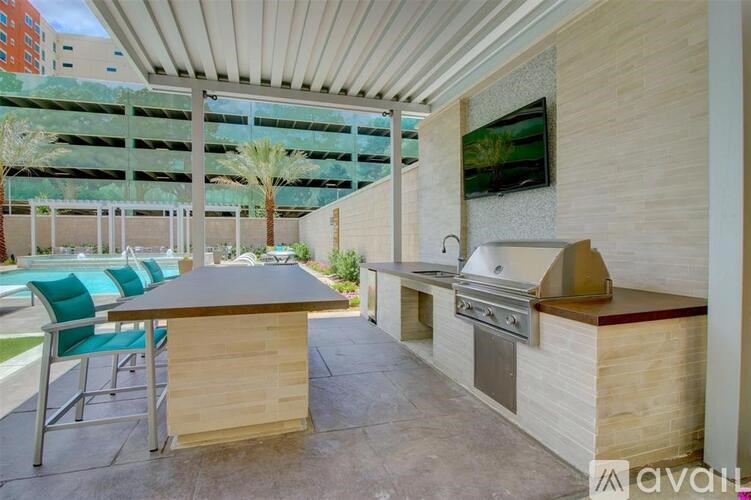 A patio with a table, chairs, and a built-in grill.