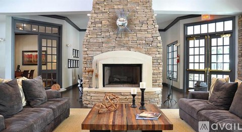 A living room with a stone fireplace and a couch.