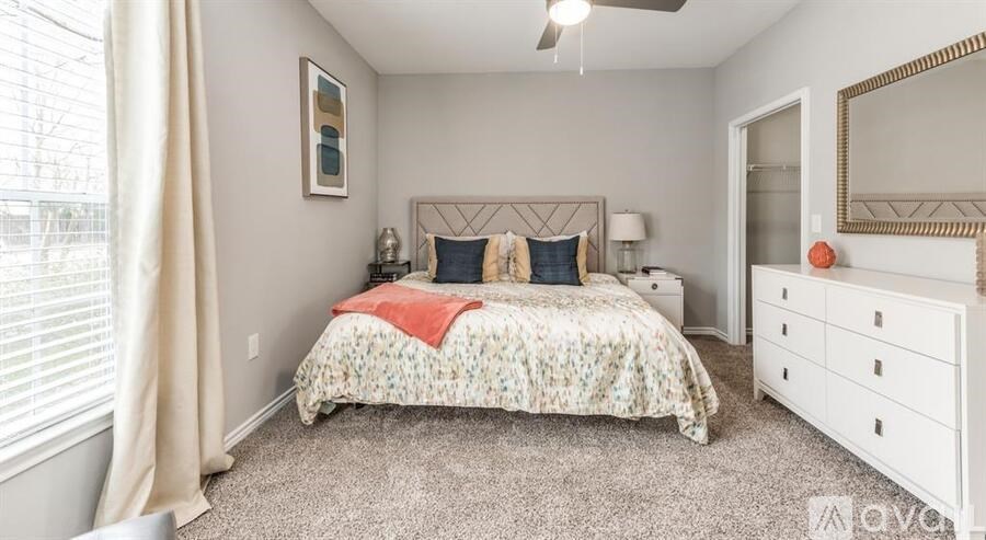 A bedroom with a bed, dresser, and mirror.