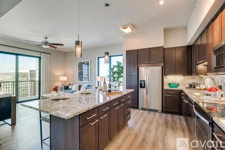 A modern kitchen with dark brown cabinets and a marble countertop.