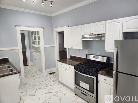A kitchen with white cabinets and a black stove top oven.