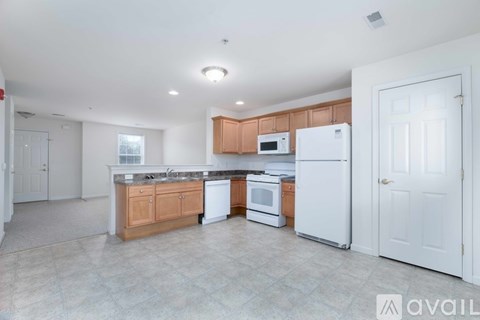A kitchen with white appliances and wooden cabinets.