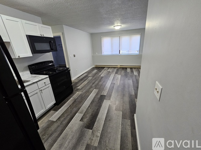 A kitchen with black appliances and white cabinets.