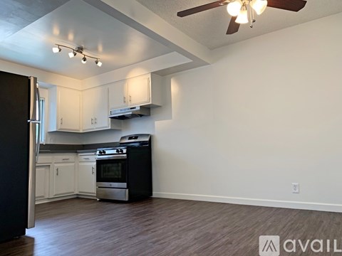A kitchen with a black refrigerator and stove top oven.