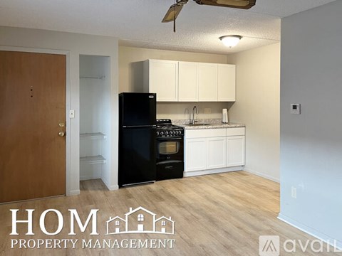 A kitchen with black appliances and white cabinets is shown.
