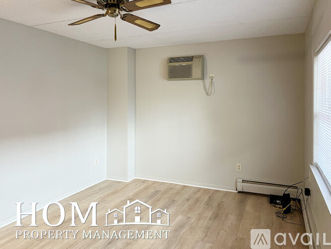 A room with a ceiling fan and a window with blinds.