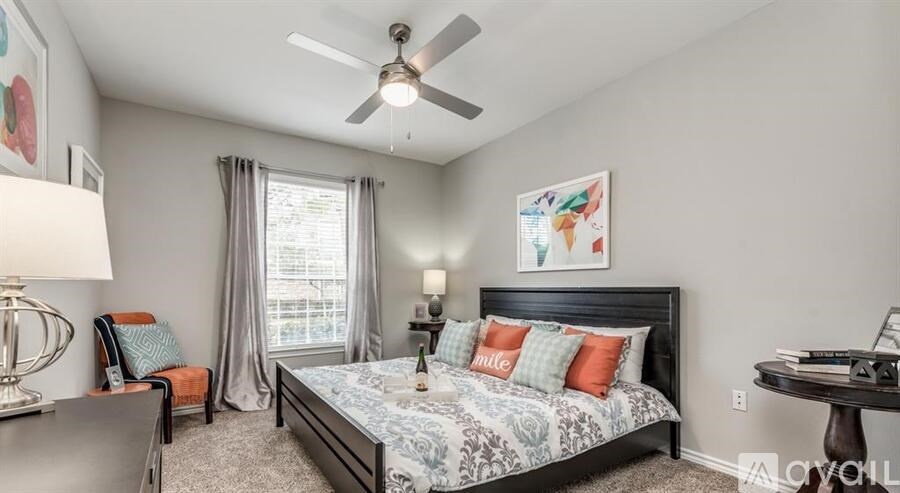 A bedroom with a bed, chair, and a painting on the wall.