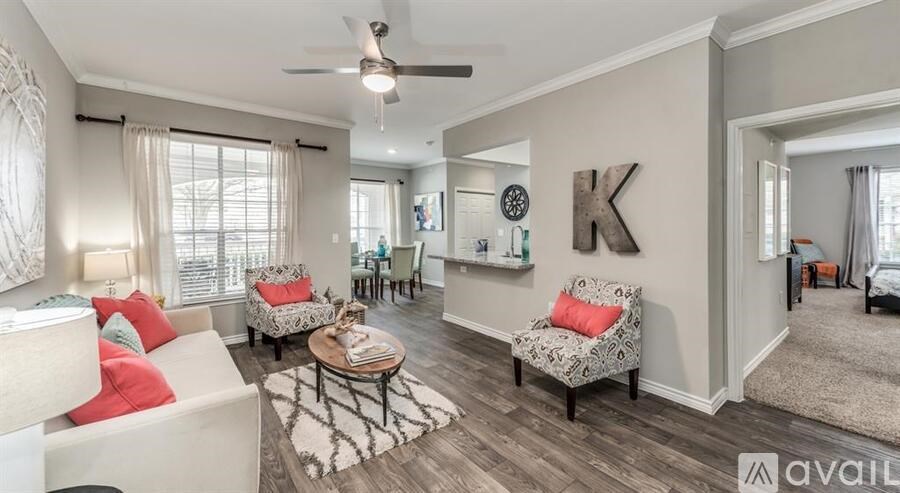 A living room with a white couch, a coffee table, and a ceiling fan.